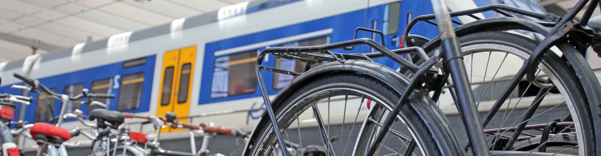 Im Vordergrund stehen Fahrräder, im Hintergrund ein Zug